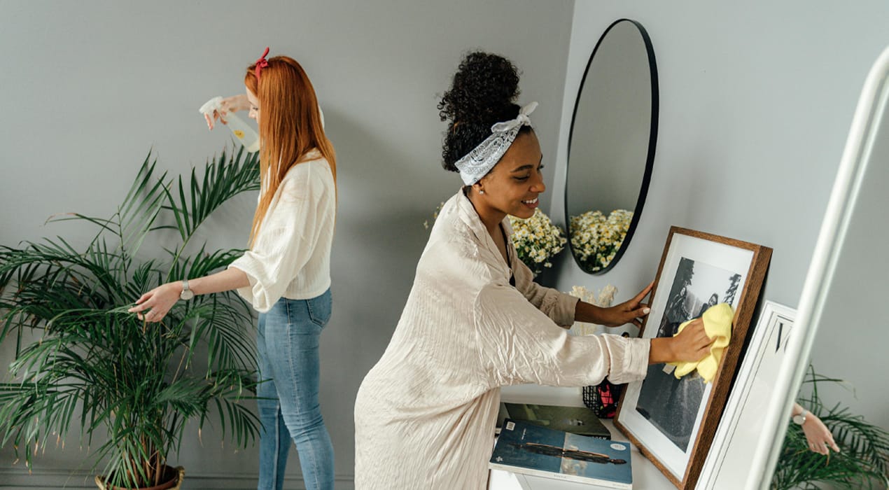Two young women cleaning house
